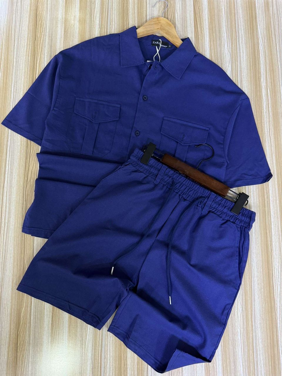 Blue shirt and shorts set on a wooden surface