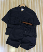 Black shirt and shorts set on a hanger against a striped background