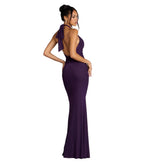 Woman wearing a purple evening gown against a gray background