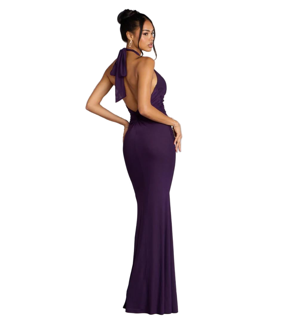 Woman wearing a purple evening gown against a gray background