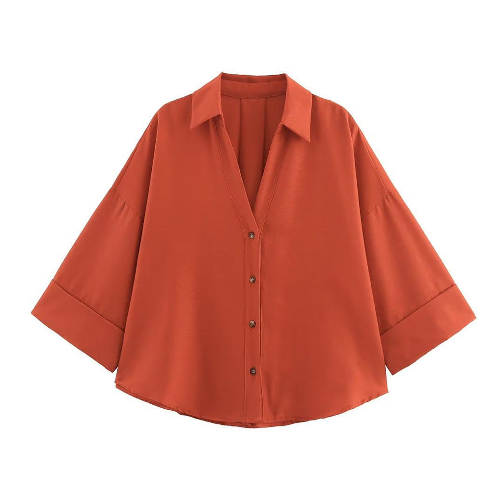 Orange button-up shirt on a white background