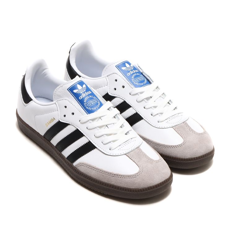 White sneakers with black stripes and a blue label on a white background