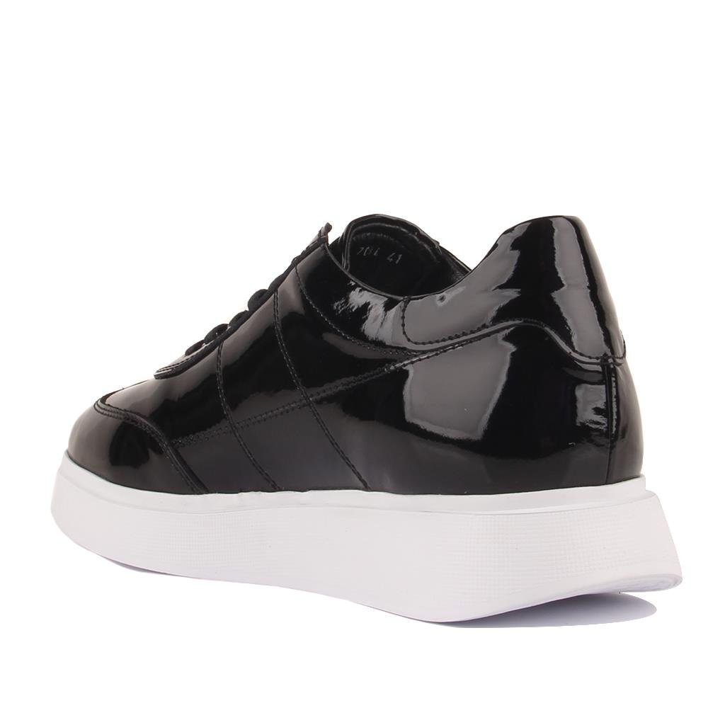 Black patent leather sneaker with a white sole on a white background