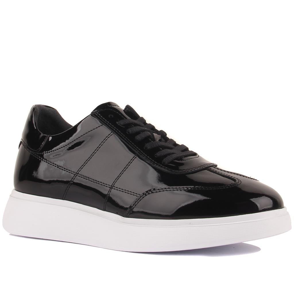 Black patent leather sneaker on a white background