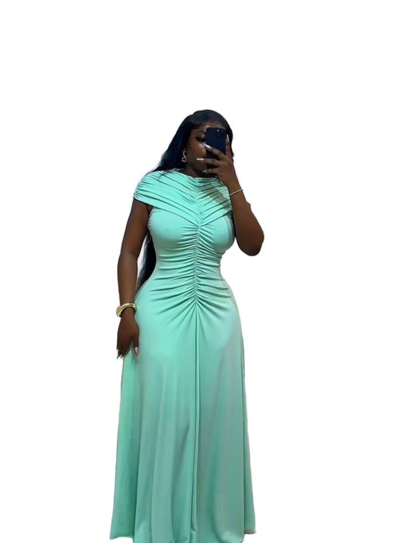 Woman in a mint green dress taking a mirror selfie in a modern living room.