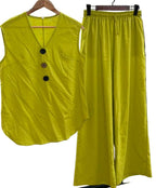 Yellow sleeveless top and wide-leg pants on hangers against a white background